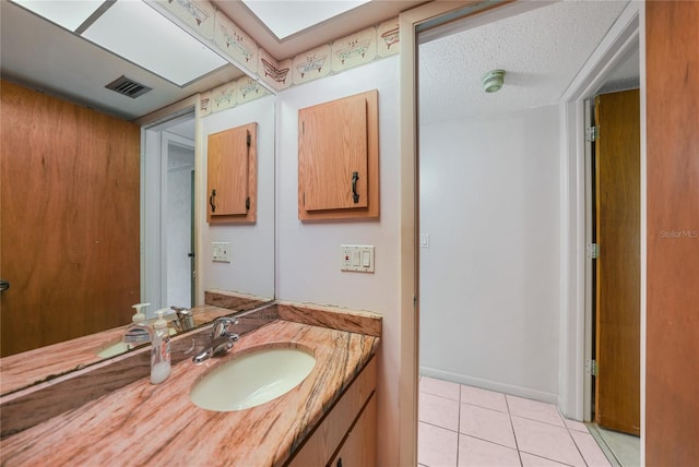 bathroom featuring tile flooring, vanity, and a textured ceiling