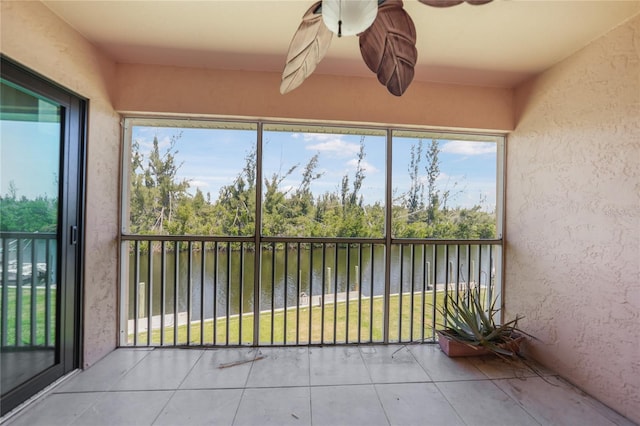 unfurnished sunroom with ceiling fan