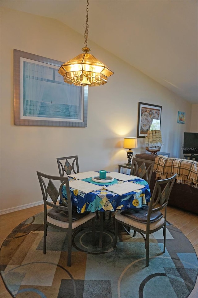 dining room with vaulted ceiling and light wood-type flooring