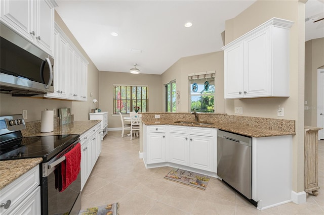 kitchen with light stone countertops, appliances with stainless steel finishes, sink, white cabinets, and kitchen peninsula