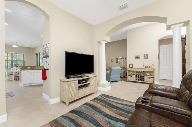 living room featuring light tile patterned flooring and decorative columns