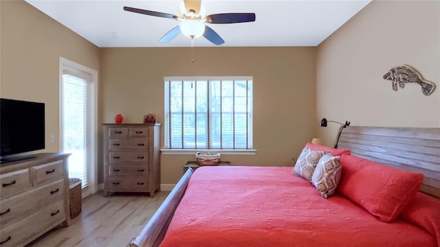 bedroom with ceiling fan, light hardwood / wood-style floors, and multiple windows