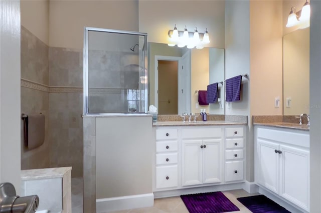 bathroom with tile patterned floors, vanity, and a tile shower