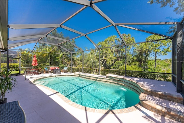 view of swimming pool featuring glass enclosure and a patio area