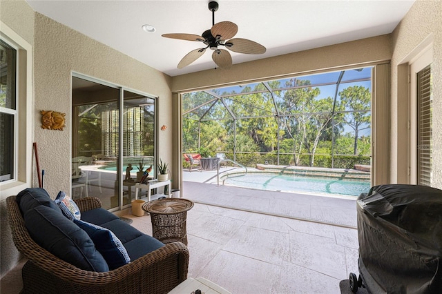 sunroom with ceiling fan and a swimming pool