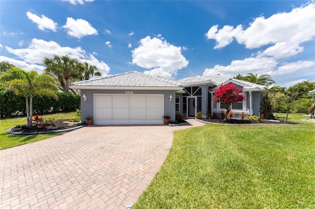 ranch-style home featuring a tiled roof, a front yard, stucco siding, decorative driveway, and a garage