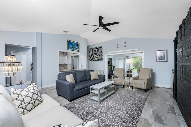 living room with ceiling fan with notable chandelier and vaulted ceiling