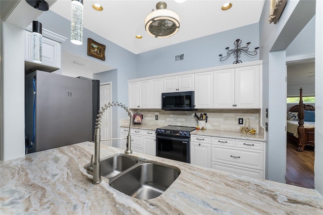 kitchen featuring sink, white cabinets, black appliances, and wood-type flooring