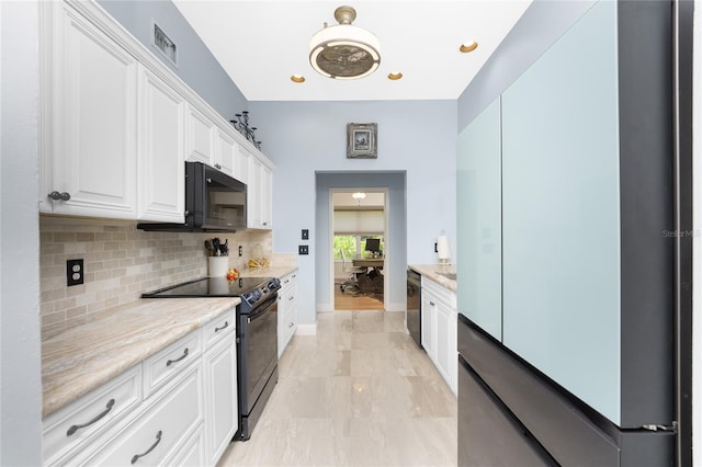 kitchen with tasteful backsplash, light stone countertops, white cabinets, and black appliances