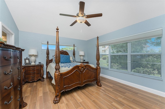 bedroom featuring ceiling fan, light wood-type flooring, and multiple windows