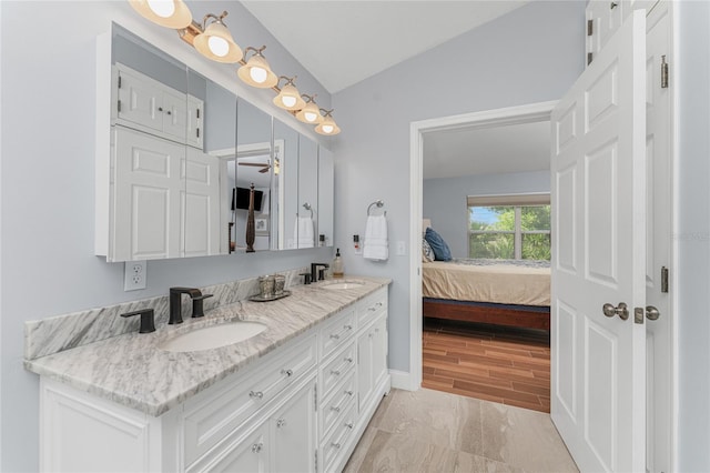 bathroom featuring vanity, wood-type flooring, and lofted ceiling