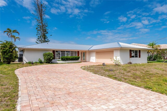 single story home with a garage and a front lawn