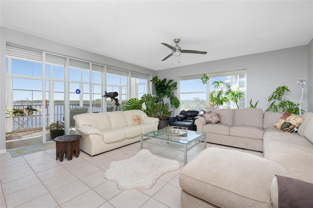 living room with a wealth of natural light, ceiling fan, and light tile flooring