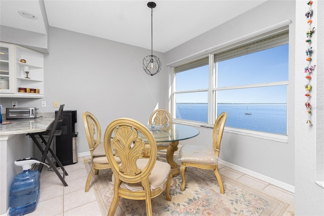 dining area with a water view and light tile floors