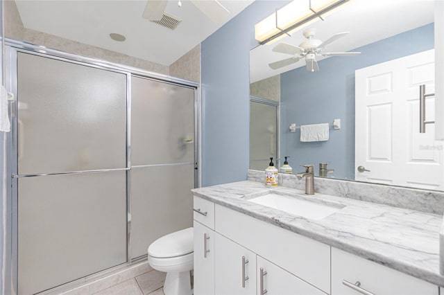 bathroom featuring a shower with door, tile floors, vanity, toilet, and ceiling fan