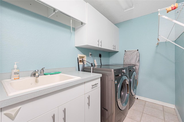 laundry room with cabinets, light tile floors, sink, washing machine and dryer, and electric dryer hookup