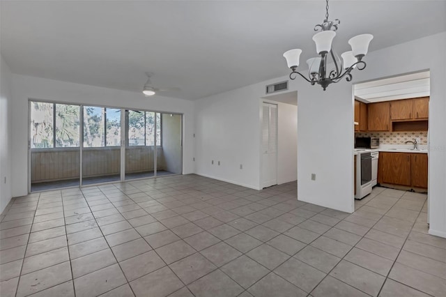 unfurnished living room featuring ceiling fan with notable chandelier, light tile patterned floors, and sink