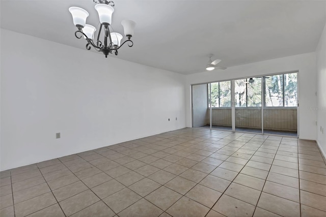 spare room featuring ceiling fan with notable chandelier and light tile patterned flooring