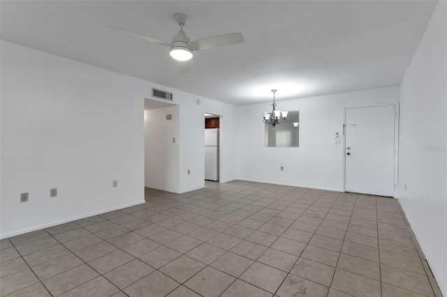 tiled empty room with ceiling fan with notable chandelier