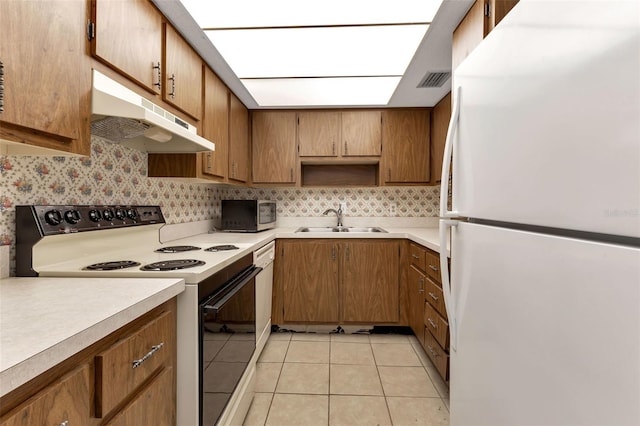 kitchen with sink, white appliances, and light tile patterned flooring