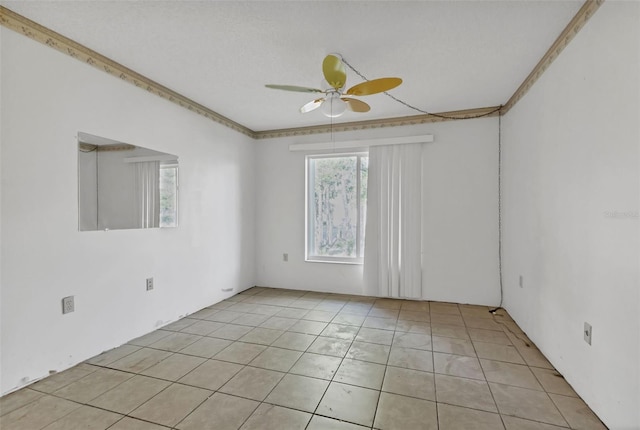 tiled spare room with crown molding and ceiling fan