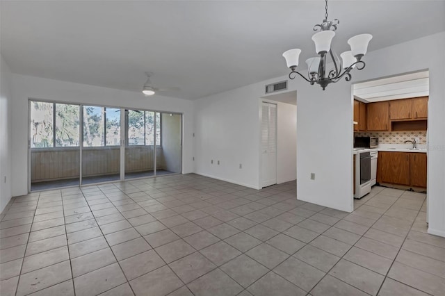 21280 Brinson Ave Unit 214, Port Charlotte, FL 33952 - unfurnished living room featuring a sink, ceiling fan with notable chandelier, light tile patterned flooring, and visible vents