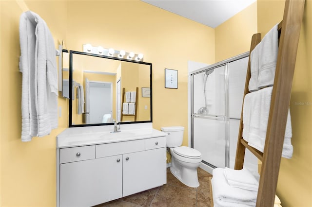 bathroom with tile patterned floors, vanity, toilet, and a shower with door