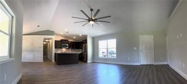 unfurnished living room with vaulted ceiling, ceiling fan, sink, and dark wood-type flooring