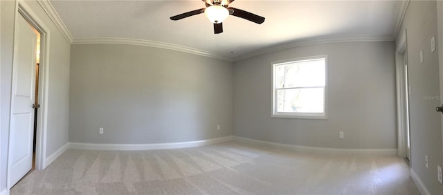 carpeted empty room featuring ceiling fan and crown molding