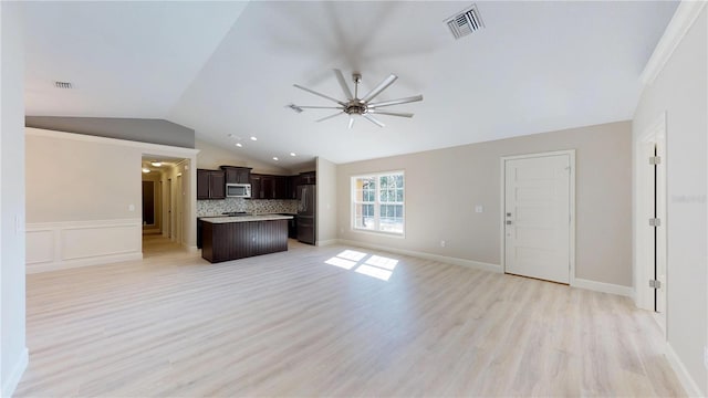 unfurnished living room with ornamental molding, lofted ceiling, light hardwood / wood-style floors, and ceiling fan