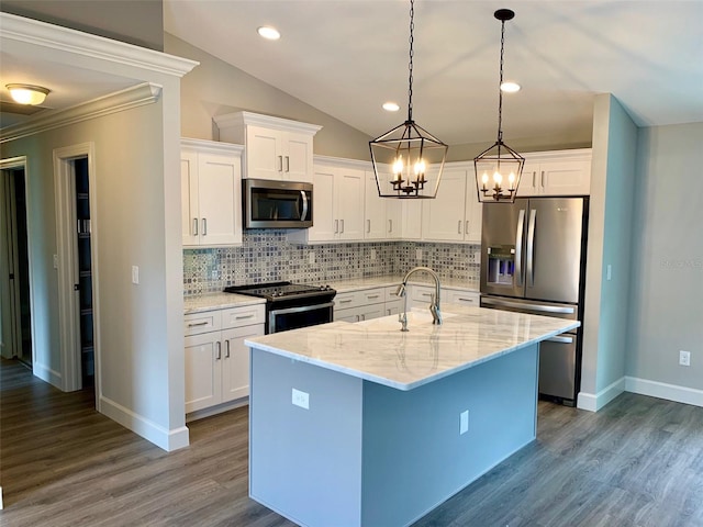 kitchen featuring appliances with stainless steel finishes, backsplash, hanging light fixtures, a center island with sink, and hardwood / wood-style flooring