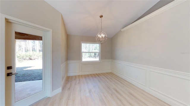 interior space with lofted ceiling, a chandelier, and light wood-type flooring