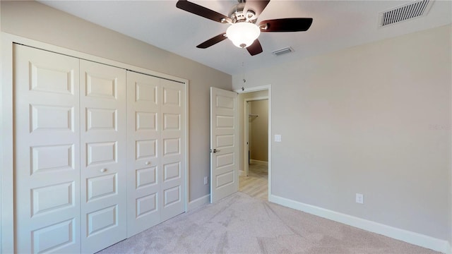 unfurnished bedroom featuring a closet, ceiling fan, and light carpet