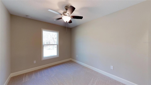 carpeted spare room with ceiling fan