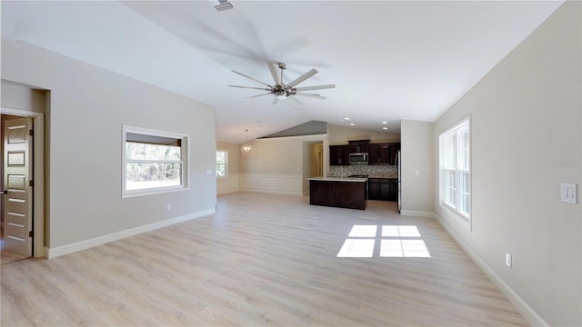 unfurnished living room with vaulted ceiling, ceiling fan, and light wood-type flooring