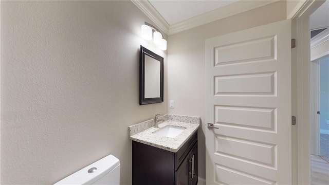 bathroom with large vanity, crown molding, and toilet