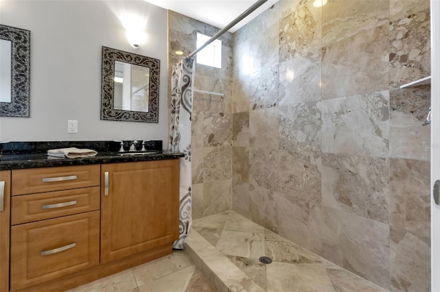 bathroom with tile flooring, walk in shower, and vanity