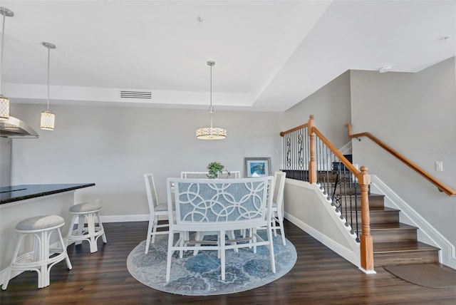 dining room featuring dark hardwood / wood-style floors and a raised ceiling