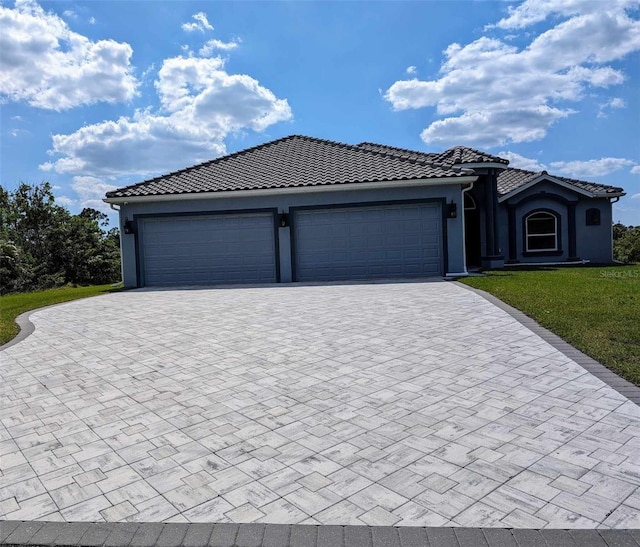 view of front of home with a garage and a front lawn