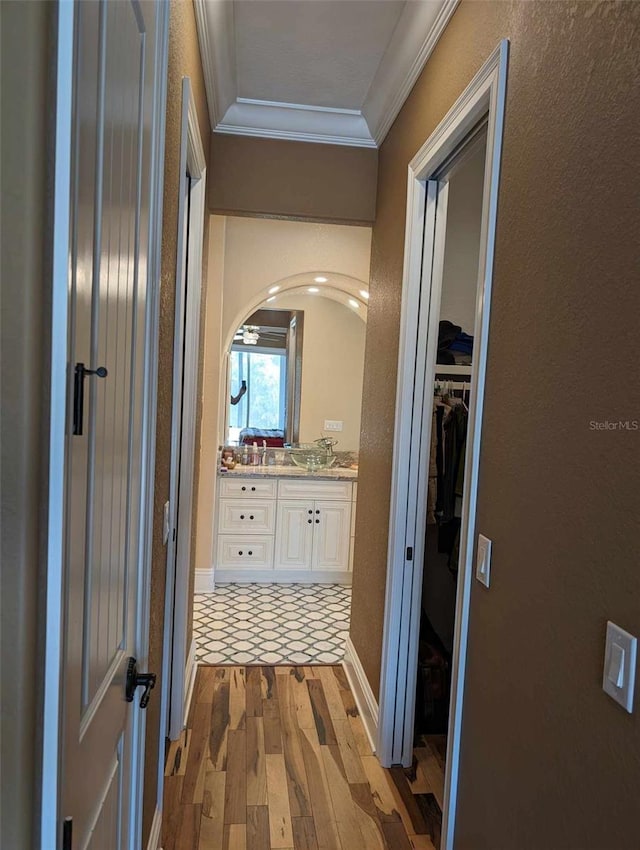 hallway with light hardwood / wood-style flooring and ornamental molding