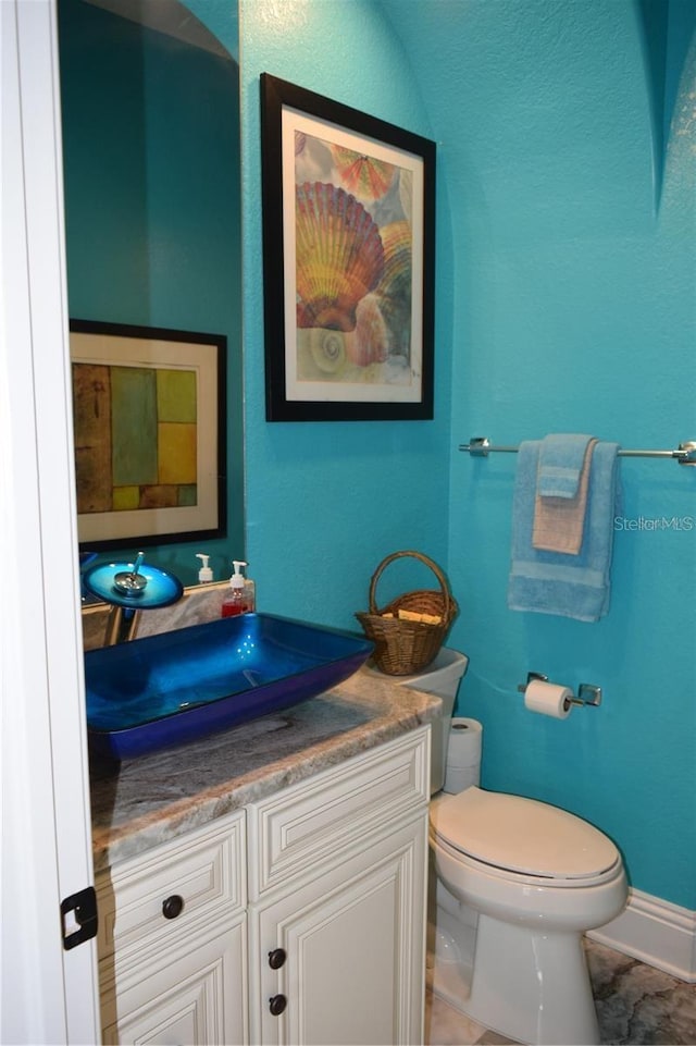 bathroom featuring vanity, tile patterned flooring, and toilet