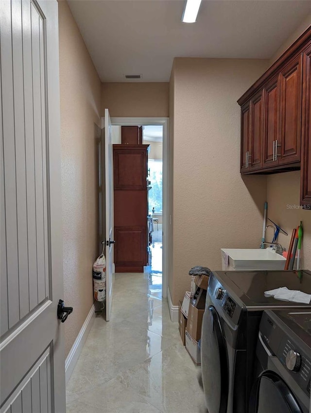 clothes washing area featuring light tile patterned flooring, independent washer and dryer, and cabinets