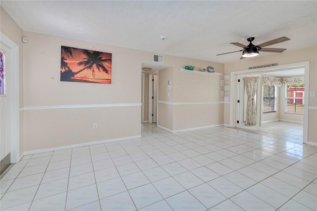 tiled spare room with ceiling fan