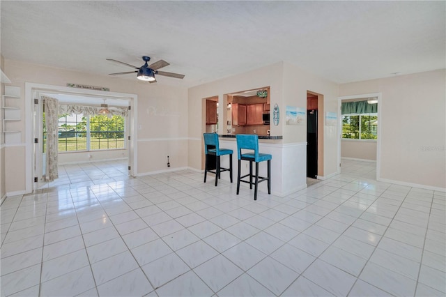 interior space with ceiling fan and light tile floors