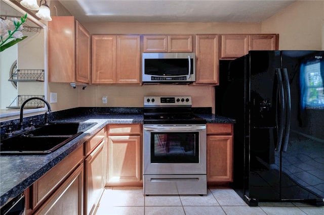 kitchen with appliances with stainless steel finishes, sink, and light tile floors