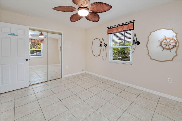 tiled spare room with ceiling fan