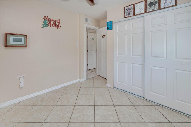 unfurnished bedroom with a closet, ceiling fan, and light tile floors