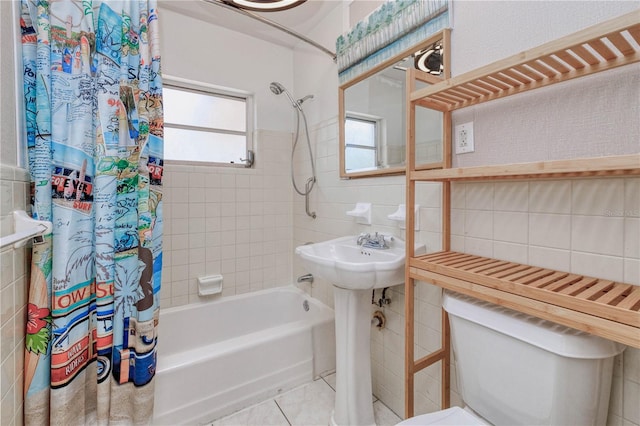 bathroom with tile flooring, a healthy amount of sunlight, toilet, and shower / tub combo with curtain