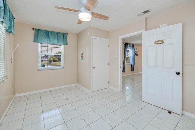 empty room featuring ceiling fan and light tile flooring