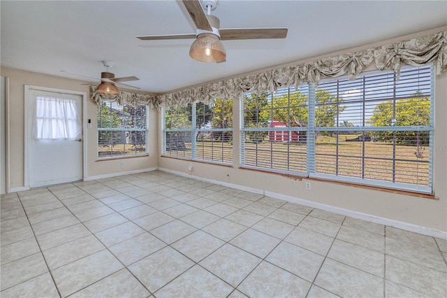 unfurnished sunroom with ceiling fan